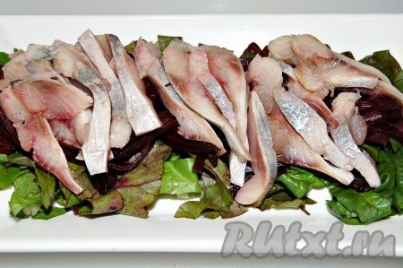 Нарезанные брусочки селедки выложить поверх свеклы.