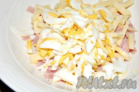Яйца (я сварила 2 яйца - 1,5 яйца добавила в салат, а половинку яйца оставила для украшения салата) сварить вкрутую (варить 8-10 минут с начала кипения воды), после остывания очистить, нарезать достаточно крупно и добавить в миску с ветчиной и сыром. Перемешать салат, заправить майонезом, если надо, подсолить.
