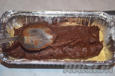 Вторую половину теста перемешать с шоколадной массой, выложить поверх светлого теста. Немного перемешать 2 вида теста для получения мраморных разводов.