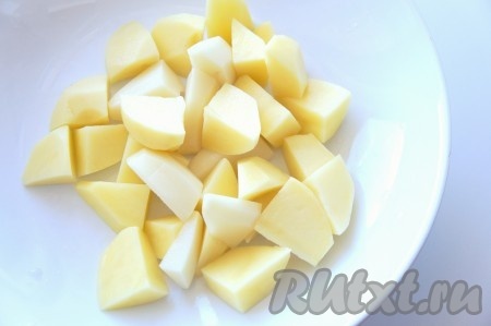 Бульон процедить, снова вылить в кастрюлю, поставить на огонь и дать закипеть. Картофель очистить, крупно нарезать, добавить в бульон, дать закипеть и варить минут 15 на небольшом огне.