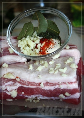 Сало моем и обсушиваем. Нарезаем на куски около 10 см в длину. Делаем надрезы в сале и нашпиговываем чесноком, остальные 5-6 зубчиков нарезаем мелко.