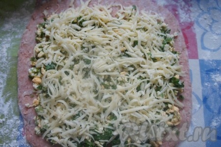 Выложить на эту основу мясного рулета начинку из смеси яйца и зелени, посыпать натёртым сыром.
