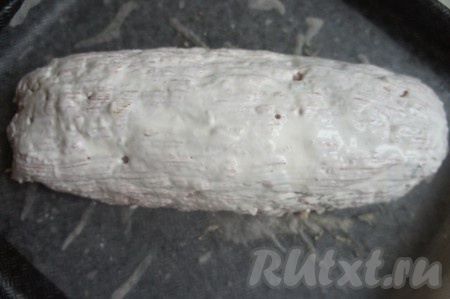 Смазать противень подсолнечным маслом, положить лист бумаги для запекания, выложить мясной рулет и смазать сметаной. Далее отправить запекаться на 40-50 минут в духовку, разогретую до 200 градусов.
