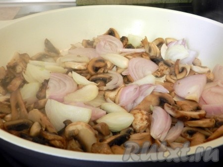 Обжарить на растительном масле грибы на среднем огне, периодические перемешивая, до золотистого цвета (в течение 7-8 минут). К обжаренным грибам добавить лук и обжарить, помешивая, до прозрачности лука (в течение 4-5 минут).