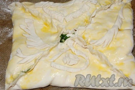 В центре оставить дырочку, через нее будет выходить пар. Смазать всю поверхность пирога из слоеного теста взбитым яйцом. Отправить пирог с разными начинками в заранее нагретую до 180 градусов духовку на 20 минут.