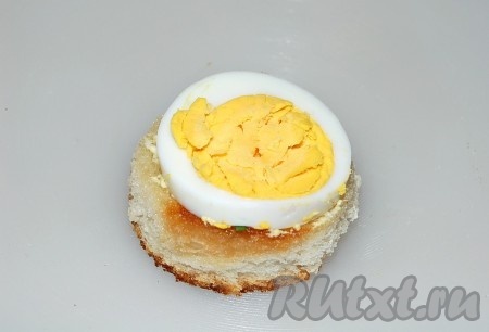 Кружочки из хлеба обжариваем на любом масле до легкой румяности, чтобы получились гренки. На каждую гренку размещаем по кружочку яйца.