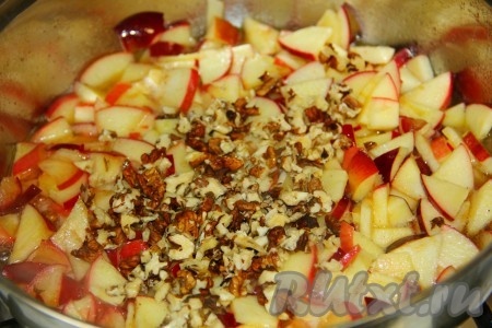 Через пару минут к яблокам отправляем измельчённые орехи. Тушим под крышкой, иногда помешивая, до тех пор, пока яблоки не станут мягкими.