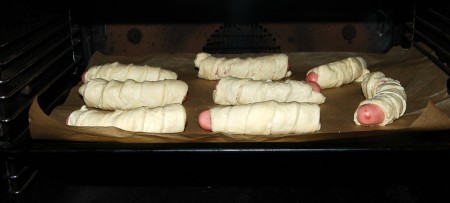 Отправить противень с сосисками в заранее нагретую до 200 градусов духовку. Выпекать примерно 30 минут.