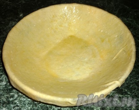 Берем теперь этот большой кусочек и раскатываем его так, чтобы он накрыл дно и бока нашей формы, и еще чуть-чуть свисал. Теперь наматываем тесто на скалку, переносим на форму. Выстилаем им нашу форму. Края теста пусть свисают. Теперь растопим сливочное масло и смажем им тесто.