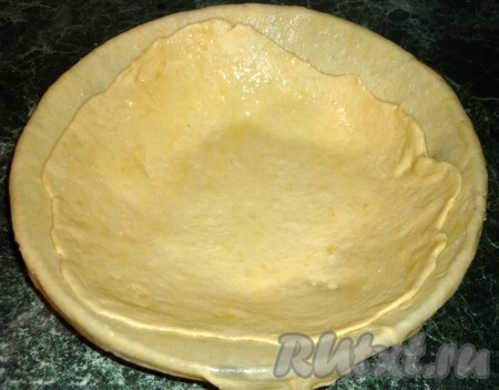 Теперь раскатаем следующий пласт, но уже до размеров дна нашей формы,толщиной, примерно, 1 мм. Переносим так же на скалке и застилаем дно. Второй пласт теста мы тоже смазываем тонким слоем масла.
