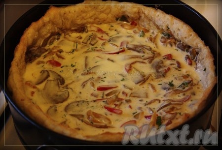 Залить грибную начинку сверху заливкой и отправить открытый пирог с шампиньонами из слоёного теста запекаться в духовку на 30-35 минут.
