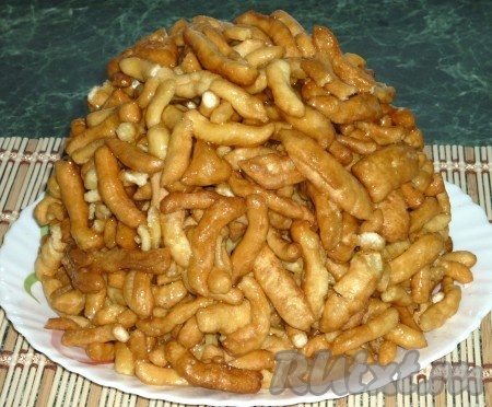 Залить тесто карамелью и сразу перемешать, чтобы карамель равномерно распределилась между кусочками теста. Слепить из приготовленного чак-чака пирамиду.