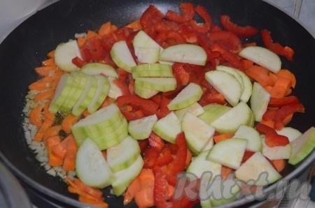 Добавить нарезанный ломтиками кабачок и сладкий перец. Тушить на небольшом огне 5 минут.