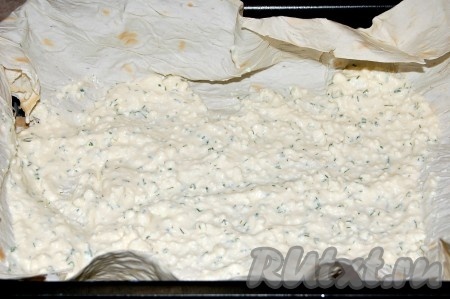 Выложить часть творожно-сырной массы поверх первого листа лаваша. Размазать по всей поверхности.