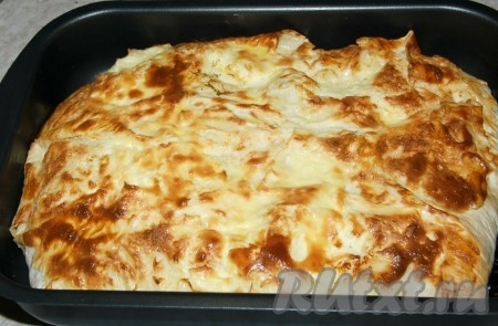 Отправить форму с ленивой ачмой из лаваша в заранее нагретую до 200 градусов духовку на 20-25 минут (выпекать до золотистого цвета). Когда ленивая ачма из лаваша будет готова, вытащить её из духовки.