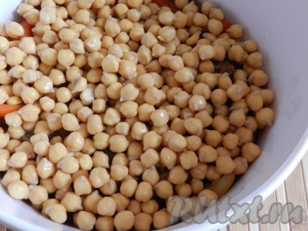 Сверху выложить нут и поставить баранину с нутом тушиться на медленном огне под крышкой примерно 40 минут. Затем блюдо посолить, добавить специи и томатную пасту. Перемешать и тушить до готовности еще 20-30 минут. Баранина должна стать мягкой.