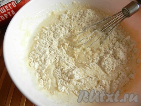 В смесь яиц, масла и сахара влить запенившуюся смесь кефира и соды, перемешать венчиком. Начать частями всыпать муку, замешивая тесто вначале венчиком.