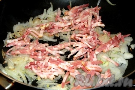 Добавить нарезанный бекон к луку на сковородку.