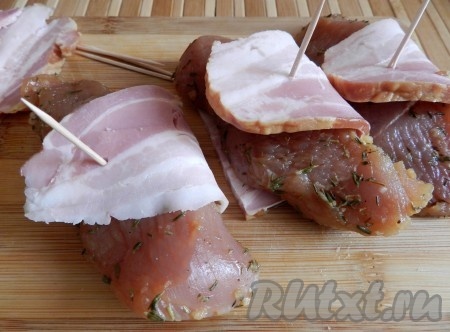 Медальоны из индейки обернуть кусочками грудинки, закрепить зубочистками.
