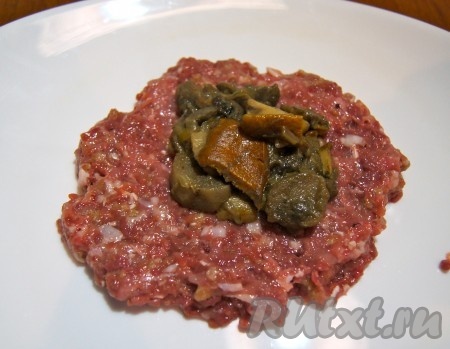 Из фарша формировать небольшие лепёшки. В центр каждой лепёшки выкладывать часть грибной начинки и защипывать края фарша, формируя котлеты.