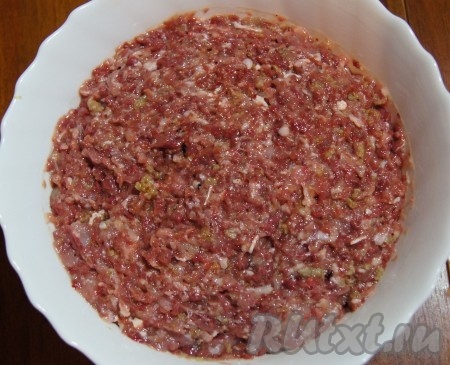 Куриное мясо, очищенные зубчики чеснока и 1 луковицу пропустить через мясорубку, посолить, поперчить получившийся фарш, добавить яйцо и 4-5 столовых ложек панировочных сухарей, тщательно перемешать. Миску с фаршем накрыть плёнкой и поставить в холодильник на 30-40 минут.
