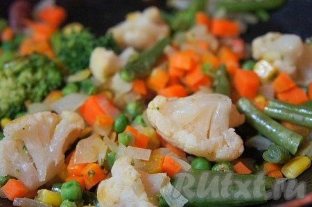 К чуть обжаренной моркови и луку добавить овощную смесь, перемешать. Накрыть крышкой и немного потушить на медленном огне около 5 минут.