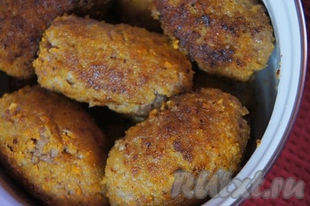 Растительное масло разогреть, добавить к нему крупно нарезанный чеснок и прокалить. Следить чтобы чеснок не подгорел. Чеснок убрать из масла. На чесночном масле обжарить котлеты до золотистого цвета. Обжаренные котлеты выложить на бумажные полотенца, чтобы удалить излишки масла. Затем переложить котлеты в кастрюлю или глубокую сковороду.
