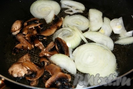 Разогреть сковородку с растительным маслом, выложить на нее нарезанный репчатый лук и нарезанные шампиньоны (у меня мороженые).
