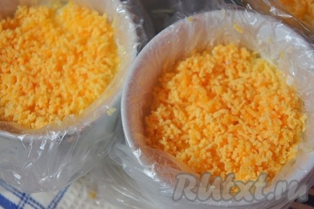 Желтки натереть на мелкой тёрке. Выложить слой желтков, разровнять.