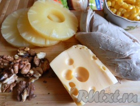 Грецкие орехи немного поджарить на сухой сковороде, иногда помешивая, снять с огня, убрать со сковороды, дать остыть, затем крупно порубить ножом (или покрошить руками). Куриное филе отварить в подсоленной воде в течение 25-30 минут с момента закипания воды, после этого достать из кастрюли и полностью остудить.