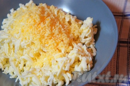 Приготовим сырную начинку для слоек. Для этого оба сыра натереть на тёрке, перемешать. Начинку разделить на 4 части и из каждой сформировать "сырный шар".