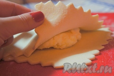 Каждую из частей одинаково раскатать, но не очень тонко.&nbsp;В центр положить сырный шарик, немного примять его рукой, накрыть другой половиной теста, края плотно прижать друг к другу, аккуратно раскатать слойку.