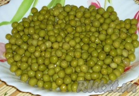 Откройте банку консервированного зеленого горошка и слейте из банки жидкость.