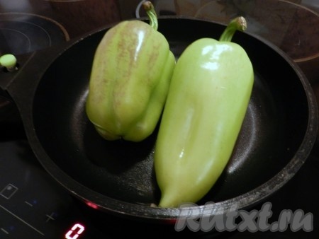 Болгарские перцы вытереть насухо. В сковороду налить немного масла, выложить перцы, накрыть крышкой и поджарить на сильном огне, периодически поворачивая всеми бочками, до мягкости перчиков.
