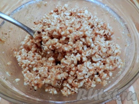 Медово-масляную смесь постепенно влить в ореховую смесь, тщательно перемешивая. Мёда может понадобиться больше или меньше, в зависимости от его густоты, поэтому смесь масла и мёда нужно вливать в ореховую смесь постепенно, чтобы масса для формирования конфет не получилась жидкой.