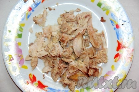 Готовое куриное мясо достаем из бульона, лук и морковь выкидываем. Бульон процеживаем и отправляем на газ. Вареное куриное мясо отделяем от костей и откладываем в сторонку.
