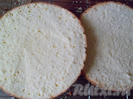 Затем испекшийся бисквит остужаем на решетке. Теплым разрезаем бисквит пополам и даём полностью остыть.
