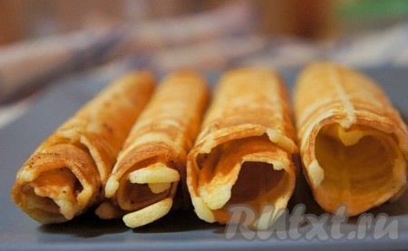 Горячую (!) вафлю с помощью ножа или вилки вытащить из вафельницы и сразу же свернуть.