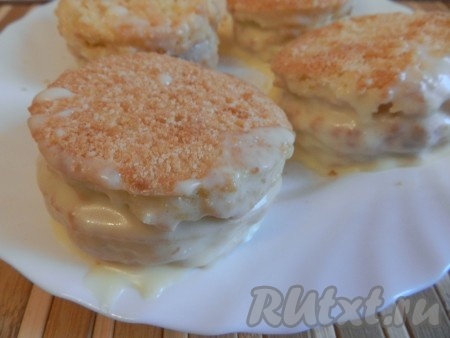 Одну сторону каждого бисквитного круга смазать кремом. Соединить бисквитные круги попарно, смазанной стороной во внутрь. Бортики получившихся пирожных тоже промазать кремом.
