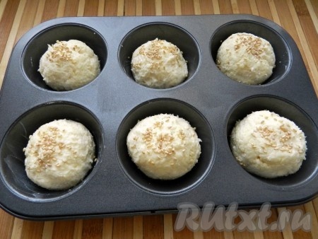 Тесто разделить на 8 частей, скатать круглые булочки. Можно выложить булочки на противень, застеленный пергаментом или разместить в формах для выпечки. Сверху булочки присыпать кунжутом.