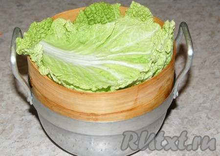 Дно пароварки выложить листьями пекинской капусты.