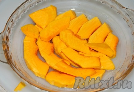 Взять форму, налить в нее растительное масло и выложить ломтики тыквы.