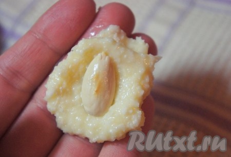 Слегка влажными руками отщипнуть небольшой кусочек охлаждённой кокосовой основы для конфет, в серединку положить миндаль и сформовать "шарик", который необходимо обвалять в оставшейся кокосовой стружке. Повторить для всех конфет, а затем отправить домашние рафаэлло охлаждаться не менее, чем на 2-3 часа.
