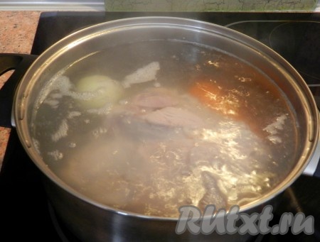 В большой кастрюле вскипятить воду. Опустить в нее мясо, довести до кипения. Когда вода снова закипит, снять пену, положить в воду морковь и луковицу, уменьшить огонь и варить под крышкой до готовности свинины 1 час или более.
