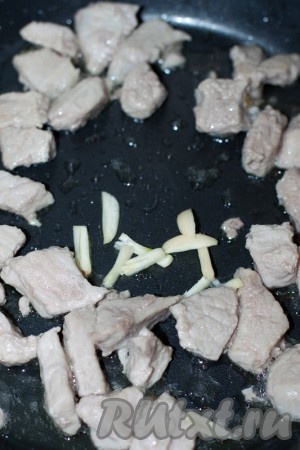 Чеснок очистить, нарезать соломкой и отправить в сковороду к мясу минутки за 3-5 до готовности. Обжаренное мясо посолить, приправить перцем, снять с плиты и держать в тепле.
