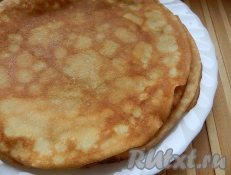 Сковороду хорошо разогреть, перед жаркой первого блина немного смазать растительным маслом. Затем влить половник блинного теста, распределить равномерно и жарить блин на среднем огне до зарумянивания с двух сторон. Перемешивая периодически тесто и смазывая сковороду по мере необходимости, постепенно пожарить все блинчики. Для использования всей начинки нам потребуется 8 блинов.