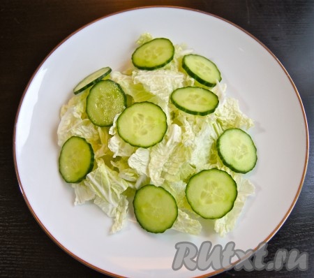 Порезала огурец и уложила на капусту.