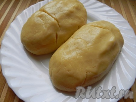 Частями добавляя оставшуюся муку и каждый раз полностью вмешивая её, замесить мягкое, не липнущее к рукам песочное тесто. Разделить его на две неравные части и убрать в холодильник на 30 минут.