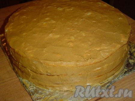 Взбиваем размягченное сливочное масло, к нему частями добавляем сгущенное молоко и взбиваем до образования пышной массы. Этим кремом смазываем верх и бока торта, а затем отправляем торт в холодильник на 5-6 часов.
