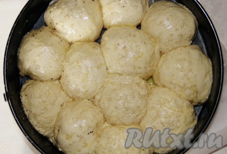 Подошедшее тесто делим на 12-18 одинаковых частей. Выкладываем в подготовленную форму для выпекания. Смазываем тесто взбитым яйцом и посыпаем кунжутом по желанию.